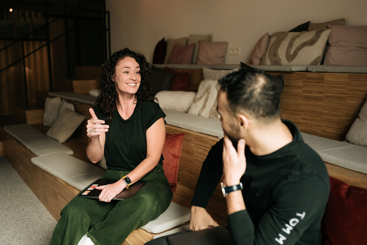 Two AE colleagues in conversation on a sofa
